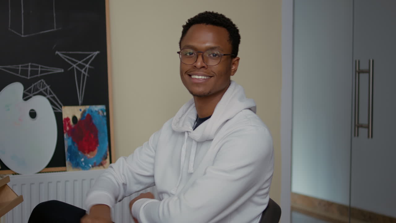 Portrait of student smiling and drawing sketch on canvas