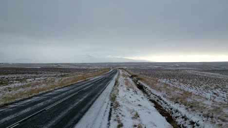 Countryside-Road-on-Stormy,-Gloomy-Day-in-Iceland---Aerial-Flight-with-No-People-and-No-Cars