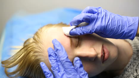 attractive lady getting facial care and eyebrow tattoo