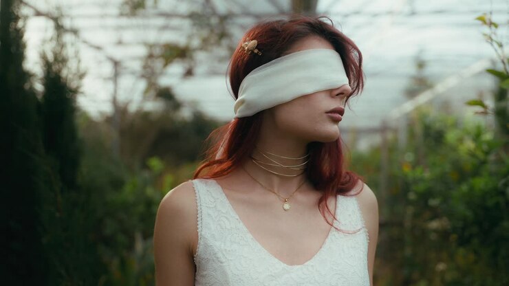 filmati cinematografici di una giovane donna in un vestito bianco e bendata che si guarda intorno in una pianta in serra