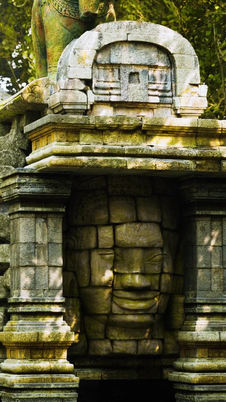 Volto in pietra scolpito in un'antica struttura vicino a un parco storico in Cambogia.