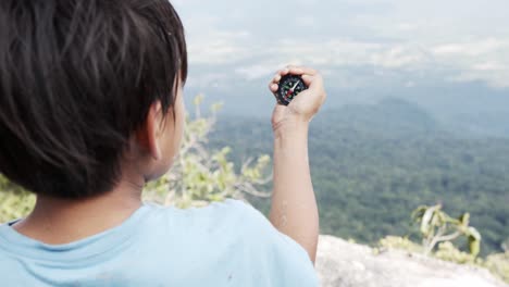 child holds the compass in his hand.