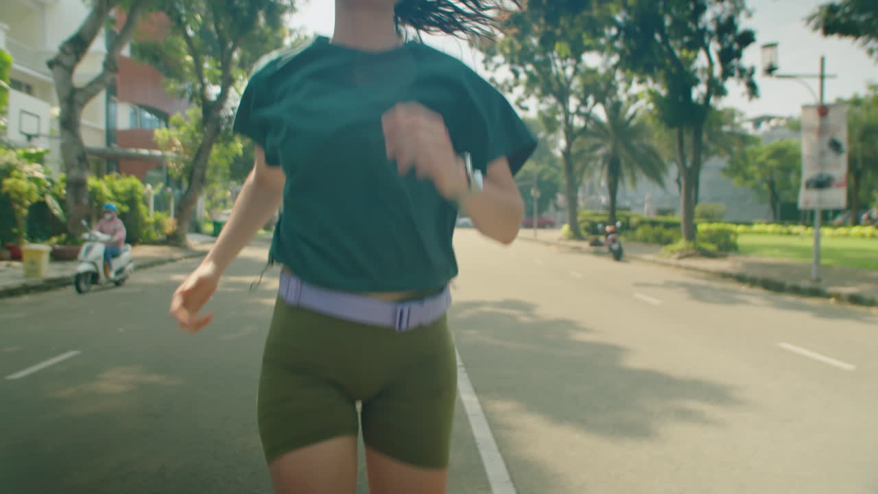 Woman Jogging along City Street on Sunny Morning