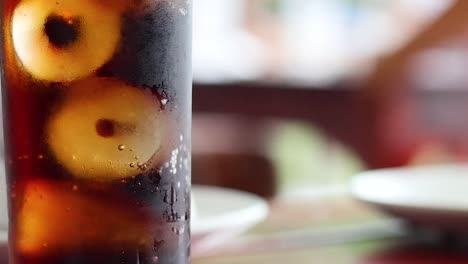 a detailed view of a glass of iced cola, highlighting bubbles and ice cubes.