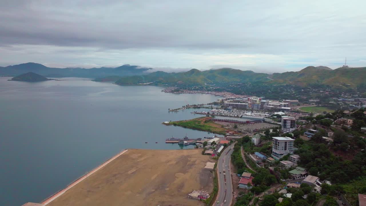 Port Moresby Harbour Marina Papua New Guinea aerial drone morning cloudy foggy sunrise PNG Crown Hotel Plaza Hilton Ela Beach Walter Bay car traffic Coral Sea coastline capital city forward motion