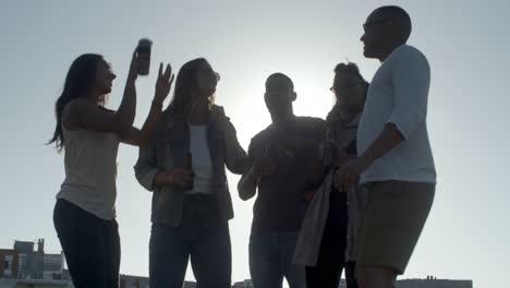 jóvenes felices bailando con botellas de cerveza.