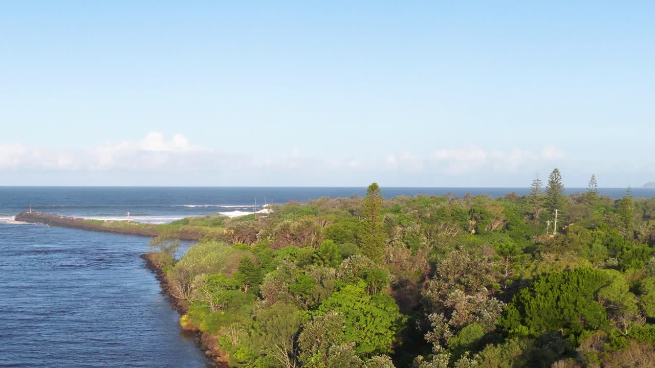 Aerial footage captures Brunswick Heads' lush greenery and winding river meeting the ocean under clear skies