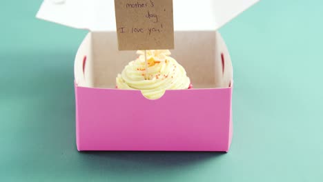 cupcake with happy mother day card against green background