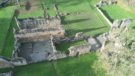 basingwerk abbey landmark medieval abandoned welsh ruins aerial view tilt down to birdseye