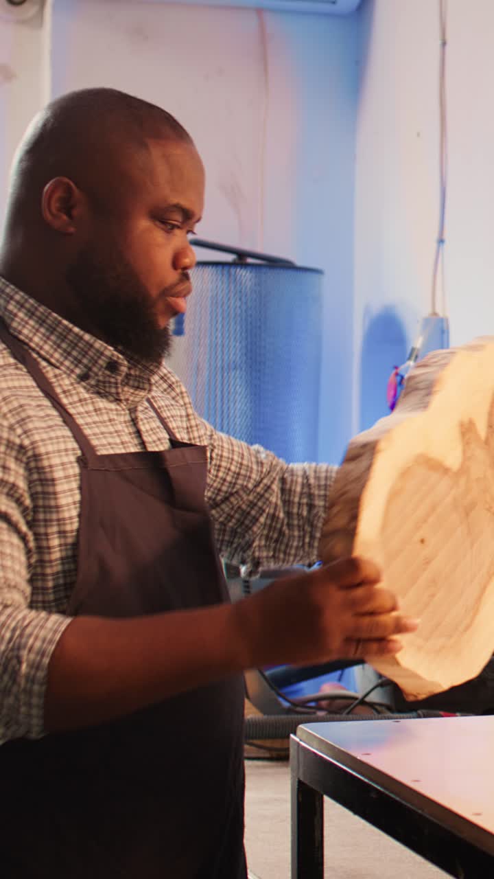 Focused Woodworker Inspecting a Wooden Slab in His Workshop