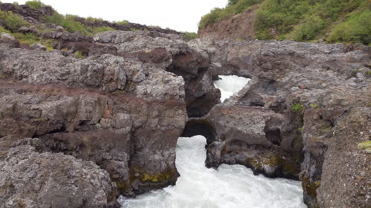 hermosa cascada de barnafoss, aguas arriba de la cascada de hraunfossar - islandia