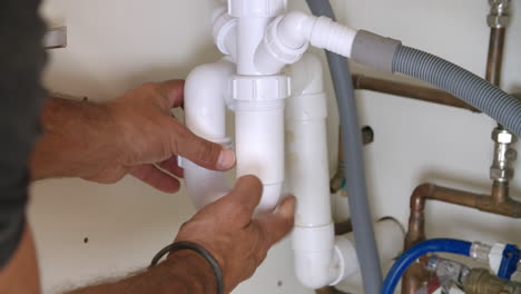 Male-plumber-fixing-a-kitchen-sink,-close-up-of-hands