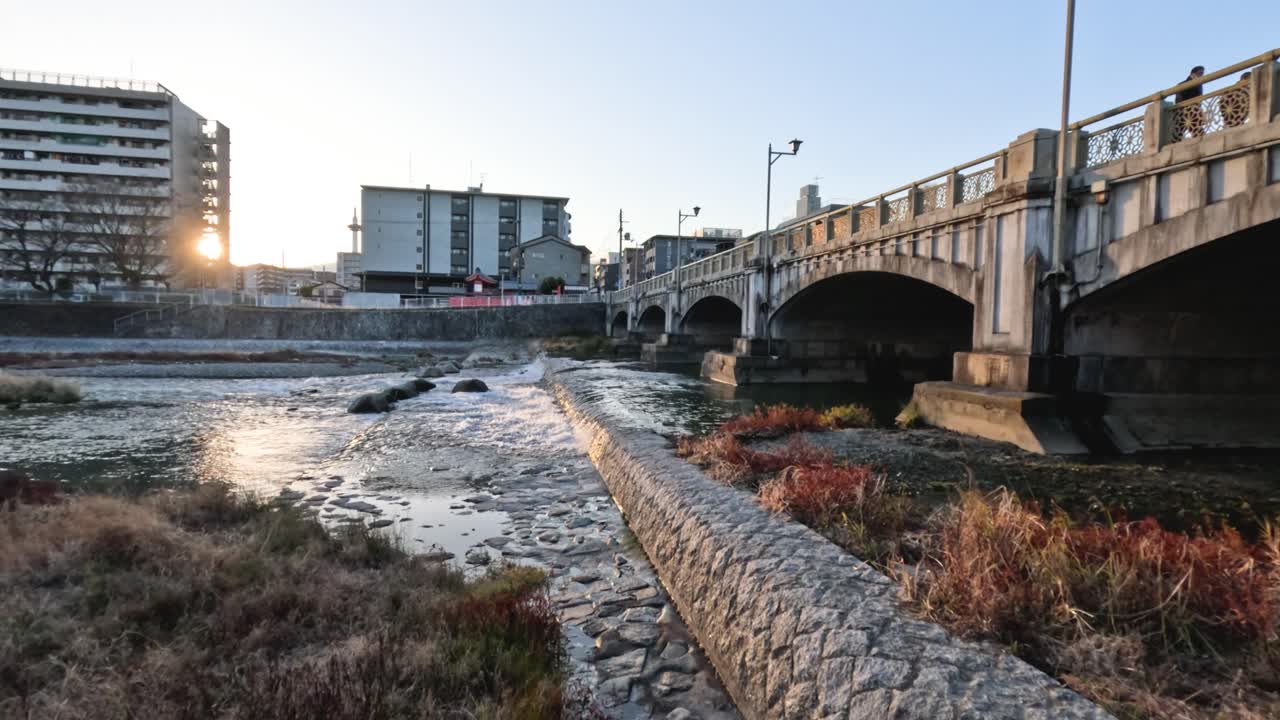 도시 의 강 을 가로지르는 다리 의 해 가 지는 모습