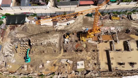 aerial view of an active construction site with tower crane and excavation