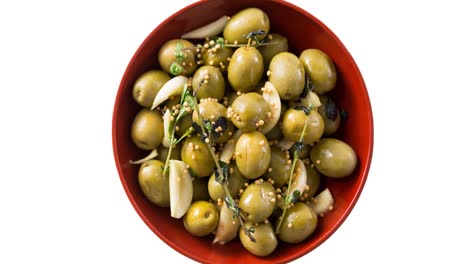 Animation-of-green-olives-in-bowl-over-white-background