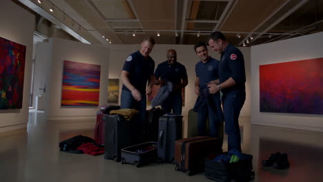 firefighters packing suitcases in an art gallery