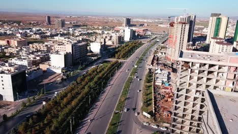 toma aérea de erbil que muestra una calle de 100 metros y un nuevo edificio en construcción.