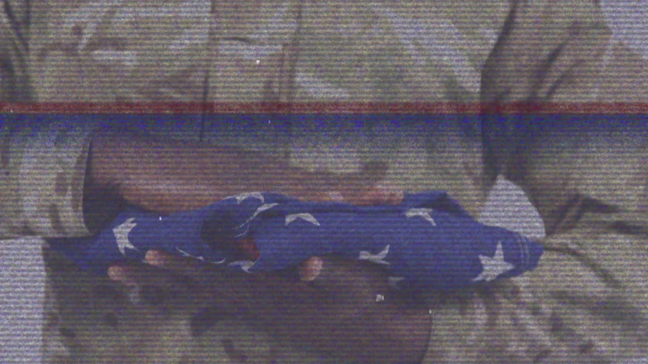 아프리카계 미국인 남성 군인이 미국 국기를 들고 있는 장면