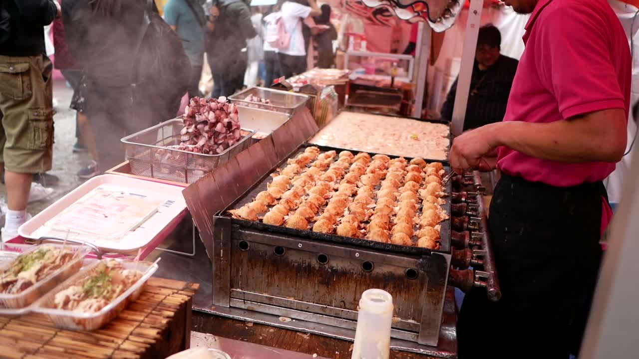 habilidad del chef con palillos cuando cocina takoyaki, la comida tradicional de japón.