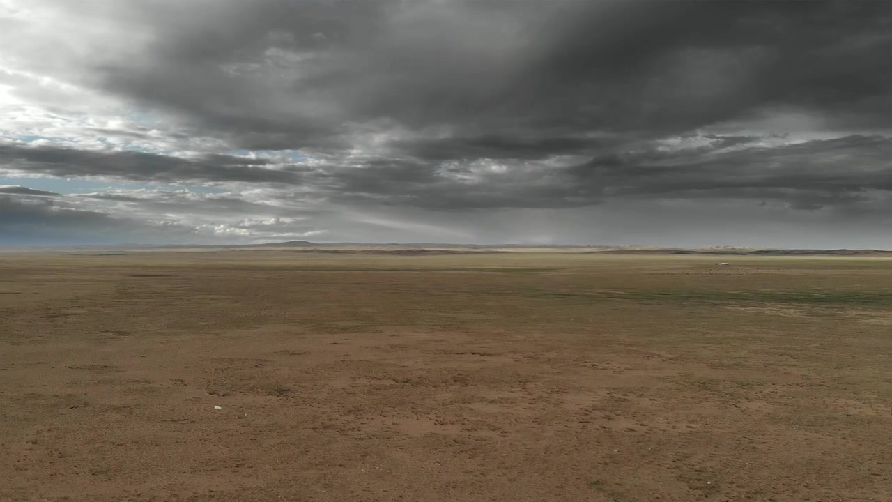 Aerial View of Vast Desert Landscape Under Stormy Clouds