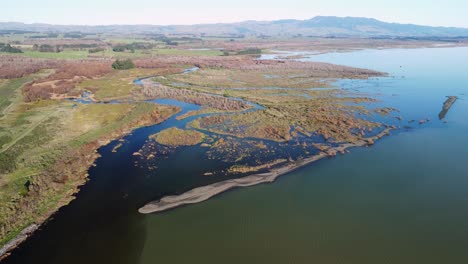 flying towards a wetland and river outlet next to a lake