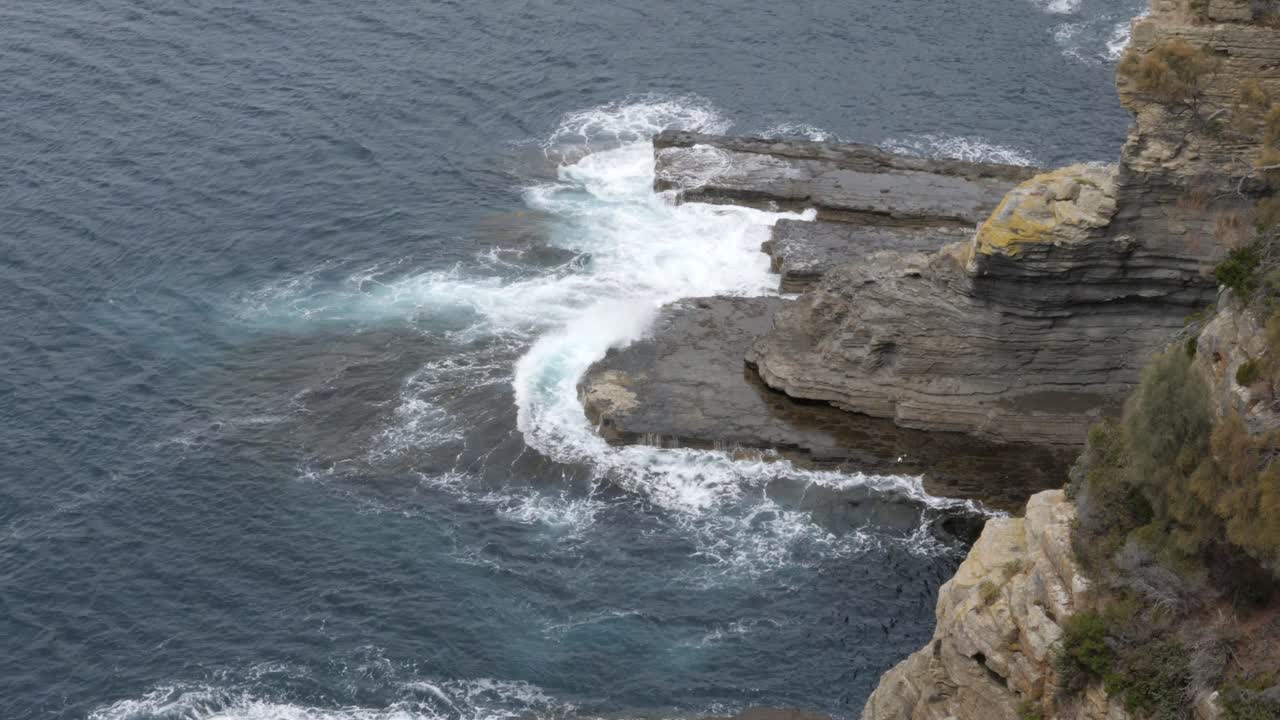 cámara lenta de olas del océano rompiendo sobre la pared rocosa, tasmania, australia