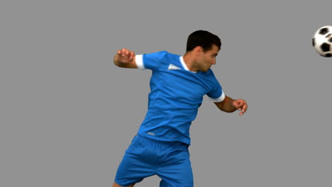 homem bonito dirigindo uma bola de futebol na tela cinzenta