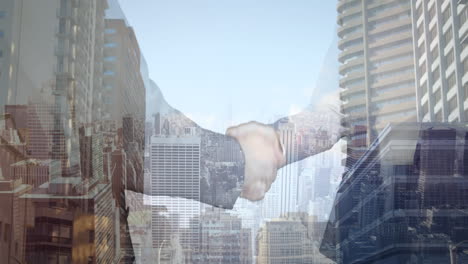 mid section of businessman and businesswoman shaking hands against aerial view of cityscape