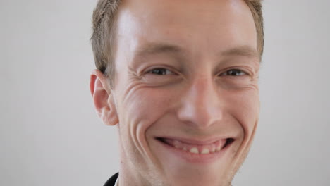 rostro masculino caucásico sonriente con gafas mirando a la cámara