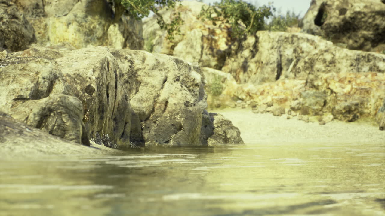 Gentle waves lap against weathered rocks at a serene shore