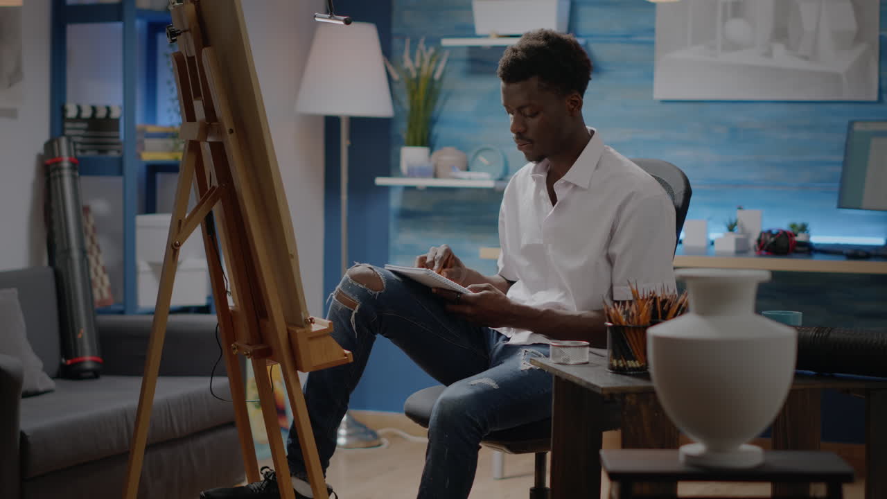 Person of african american ethnicity working on vase sketch