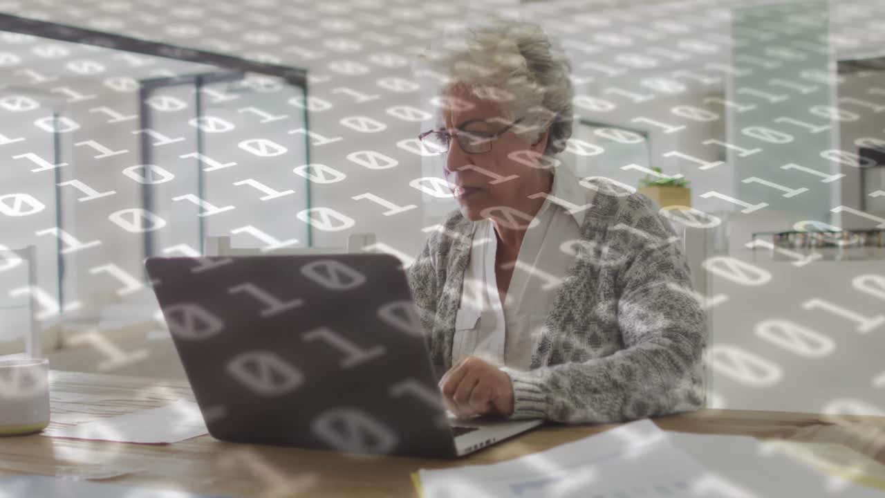 video compuesto de procesamiento de datos de codificación binaria contra una mujer mayor afroamericana que usa una computadora portátil