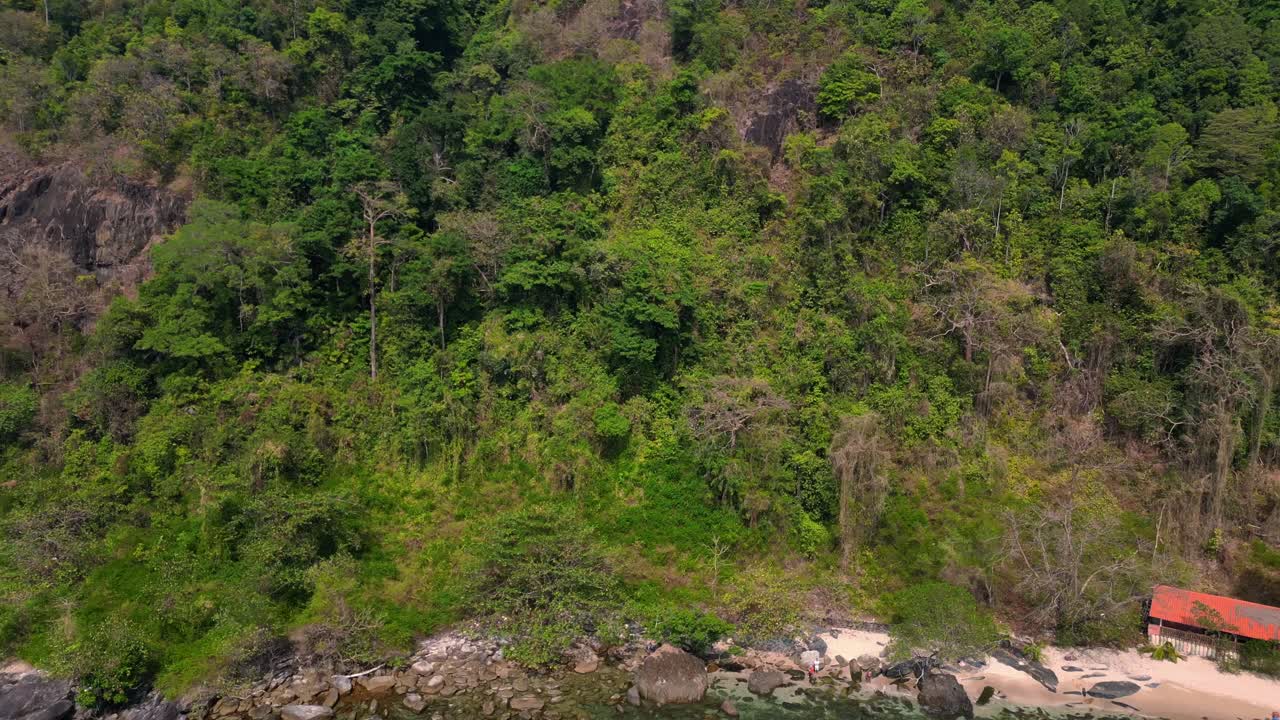 koh chang Island, thailand showing a beautiful tropical white sand beach and lush rainforest meeting turquoise water. Tremendous aerial view flight pull in drone
