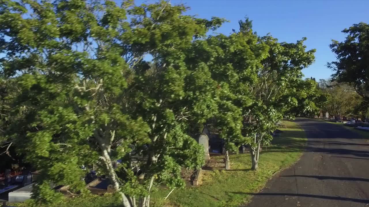 seguimiento de drones aéreos y tiro ascendente que se mueve lateralmente pasando tumbas a medida que se eleva para revelar un enorme cementerio suburbano