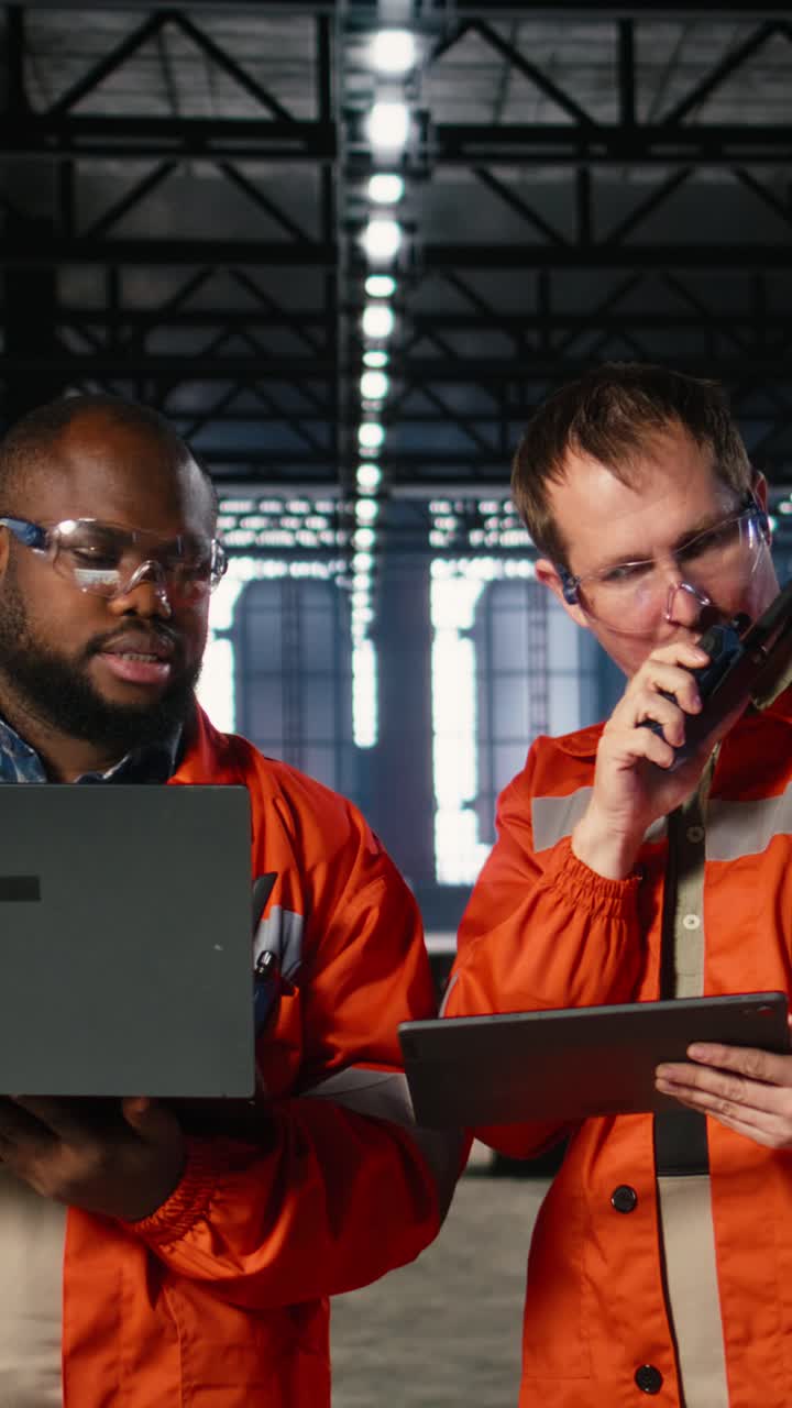 Vertical Video Diverse workers using devices to manage steel production tasks