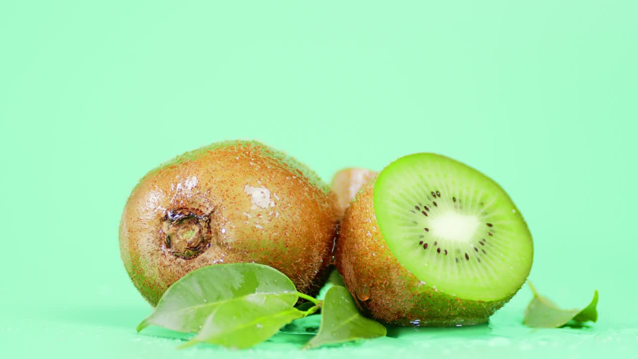 kiwi fresco com folhas caindo gotas de água.