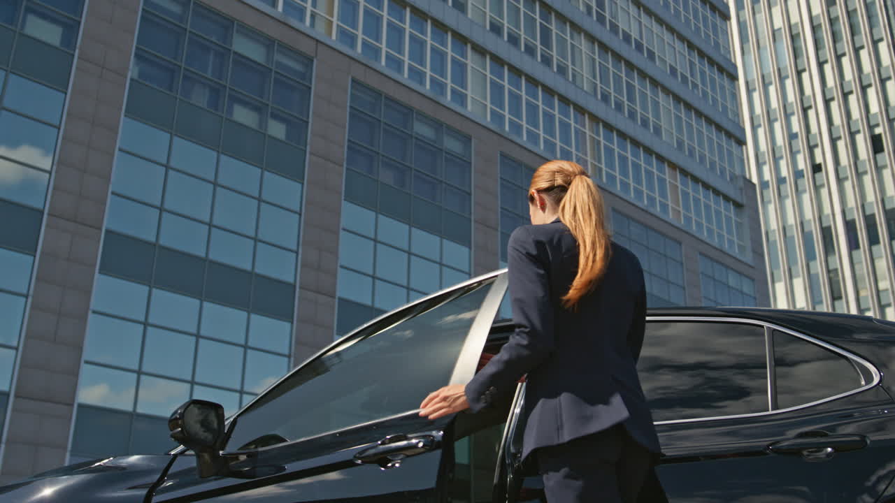 여성 운전자는 값비싼 차에 앉아 거리에 서 있습니다. 우아한 사업가입니다.