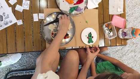 mom and child decorating halloween cookies