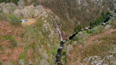 aerial drone shot of water falling into the sor river at the viewpoint of aguas caídas, manón, lugo, galicia, spain during daytime