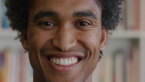 portrait happy african american student man smiling bookshelf