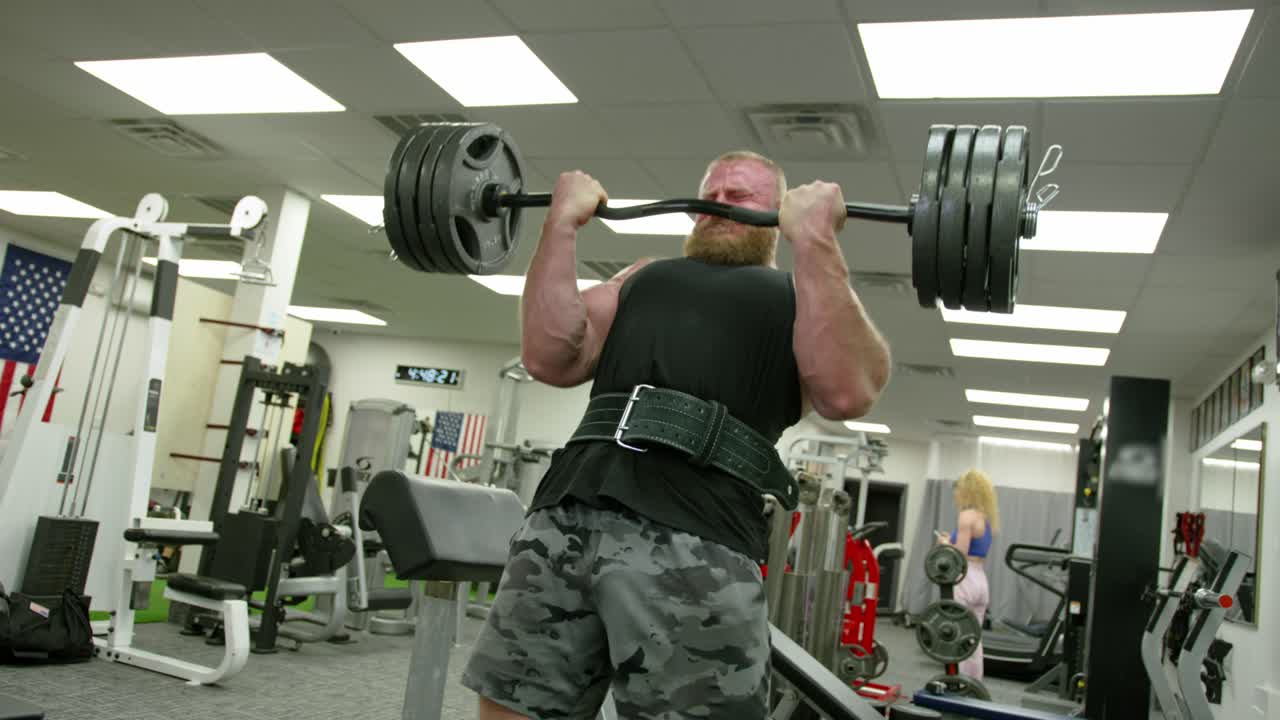 Young Adult Man Strenuously Working Out at Gym