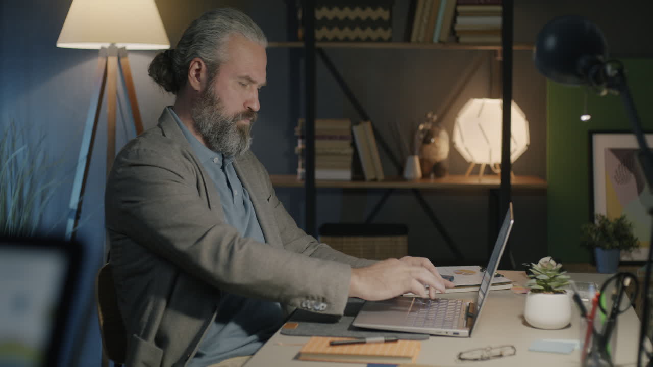 Man working late at night on laptop in home office