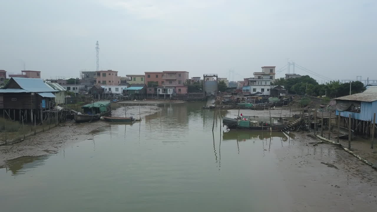 Aerial shot of a polluted river near the village in Asia