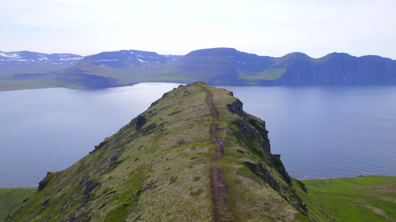 아이슬란드 웨스트피오르드 (westfjords) 의 외 ⁇  호른스트란디르 자연보호구역 (hornstrandir nature reserve) 의 산맥에서 하이킹을 하는 사람들 위에서 대단한 드론 비행