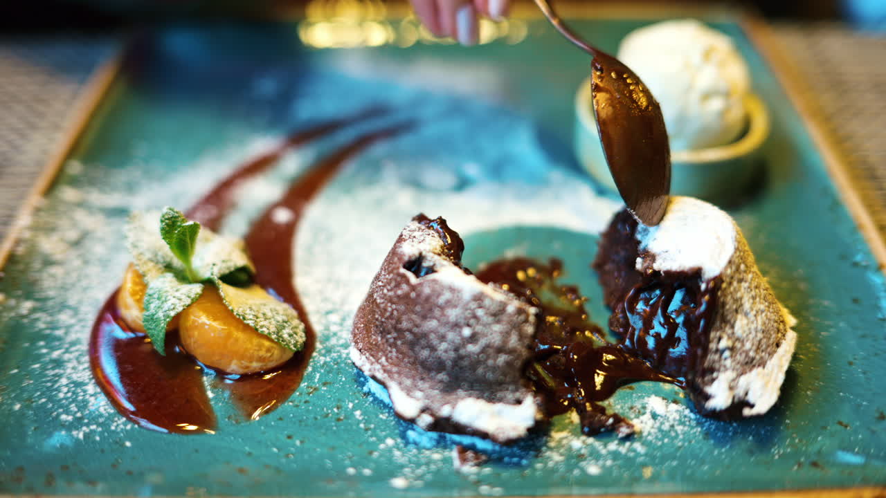Chocolate lava cake with ice cream and orange decoration in a restaurant