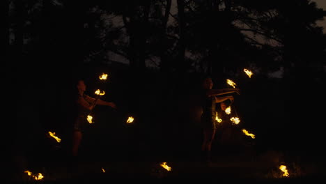fire jugglers in the forest at night