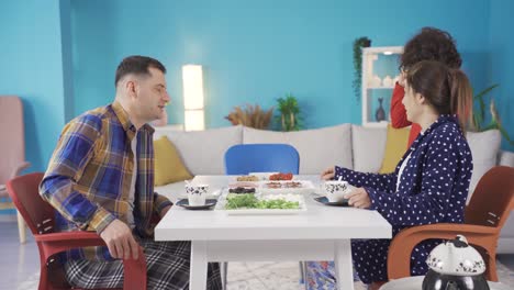 Happy-family-boy-waking-up-for-breakfast-and-his-parents-smiling-at-him.