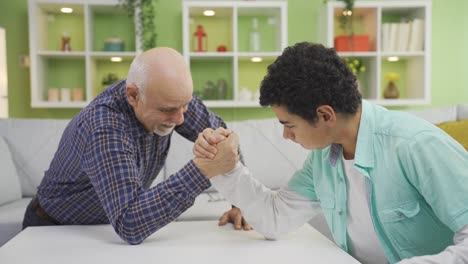 The-grandfather-is-arm-wrestling-with-his-grandson,-who-is-in-the-developmental-age.