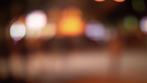 calle de noche con iluminación y caminando la gente borrosa