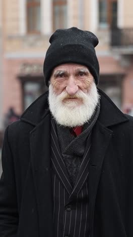 portrait of an elderly man in a coat and hat